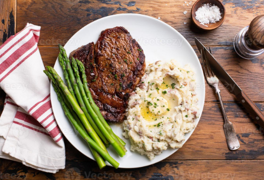 Steak de carne com pure de inhame e aspargos